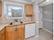 Well-lit kitchen area with essential appliances, wood cabinetry, and a view from the window at 6025 Shore S Blvd # 311, Gulfport, FL 33707