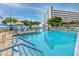 Large, inviting pool with plenty of seating, lush landscaping, and a glimpse of the building beyond at 6025 Shore S Blvd # 311, Gulfport, FL 33707