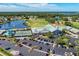 Aerial view showcasing community amenities including a pool, clubhouse, tennis courts, and scenic lake at 6303 Green Oak Cir, Bradenton, FL 34203