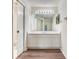 Bathroom features a large vanity, a sizable mirror, tiled floors, and a door that leads to the toilet and shower at 6303 Green Oak Cir, Bradenton, FL 34203