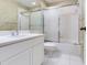 Clean bathroom with vanity, tiled floor, large mirror, toilet, and shower with sliding doors at 6303 Green Oak Cir, Bradenton, FL 34203