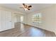 Bright bedroom features wood-look floors, ceiling fan and sliding mirror door closet at 6303 Green Oak Cir, Bradenton, FL 34203
