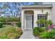 Welcoming front entrance with a neutral-colored door, complemented by mature landscaping and lake view at 6303 Green Oak Cir, Bradenton, FL 34203