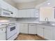 Modern kitchen with white cabinets and appliances plus ample counter space at 6303 Green Oak Cir, Bradenton, FL 34203