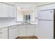 Bright kitchen features white cabinetry, subway tile backsplash, and stainless-steel appliances overlooking the living area at 6303 Green Oak Cir, Bradenton, FL 34203