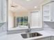 Modern kitchen sink and countertops looking into the living area and out to the screened lanai and pond at 6303 Green Oak Cir, Bradenton, FL 34203