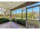 Enclosed lanai with tiled flooring offering a beautiful view of the pond surrounded by lush trees at 6303 Green Oak Cir, Bradenton, FL 34203