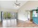 Bright and airy living room featuring tile floors, a ceiling fan, and sliding doors with views of the lake at 6303 Green Oak Cir, Bradenton, FL 34203
