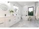 Bright bathroom with dual vanity, sleek fixtures, and a freestanding tub at 716 S Lois Ave, Tampa, FL 33609