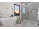 Modern bathroom featuring a soaking tub, a glass-enclosed shower with striking gray stone tiling, and contemporary fixtures at 716 S Lois Ave, Tampa, FL 33609