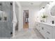Bright bathroom featuring a double vanity, sleek hardware, and a glass-enclosed shower with gray stone tiling at 716 S Lois Ave, Tampa, FL 33609