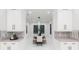 Dining area with modern hanging light fixtures and neutral accents, framed by bright white cabinetry at 716 S Lois Ave, Tampa, FL 33609