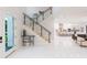 Open-concept foyer showcases stairs with glass, leading to a living area and modern kitchen with a large island at 716 S Lois Ave, Tampa, FL 33609