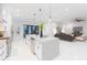 Bright, open-concept kitchen and living room with island, stainless appliances, and modern pendant lighting at 716 S Lois Ave, Tampa, FL 33609