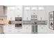 Stylish kitchen featuring stainless steel appliances, white cabinetry, and sleek wine storage at 716 S Lois Ave, Tampa, FL 33609