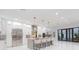 Modern kitchen features an island with seating, stainless steel appliances, marble floors, and access to the outdoors at 716 S Lois Ave, Tampa, FL 33609
