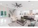 Open living area features a staircase, modern furniture, and a view into the adjacent kitchen and outdoor area at 716 S Lois Ave, Tampa, FL 33609