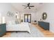 Light-filled main bedroom boasts modern decor, wood floors, and a ceiling fan at 716 S Lois Ave, Tampa, FL 33609