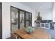 Outdoor dining area featuring a wooden table, built-in kitchen with a grill, and views of the interior at 716 S Lois Ave, Tampa, FL 33609