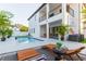 Backyard showcasing a modern two-story home, refreshing swimming pool, and stylish outdoor lounge area at 716 S Lois Ave, Tampa, FL 33609