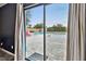 View of the backyard pool through slider door and white drapes at 7405 41St Ave N, St Petersburg, FL 33709