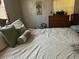 Bright bedroom with a comfortable bed, wooden dresser, and neutral decor at 12501 Ulmerton Rd # 140, Largo, FL 33774