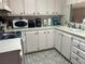 Functional kitchen featuring white cabinets, appliances, and a sink with plenty of counter space at 12501 Ulmerton Rd # 140, Largo, FL 33774