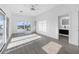 Bright bedroom boasts gray flooring, ceiling fan, and sliding glass doors leading to a balcony at 18077 3Rd St, Redington Shores, FL 33708