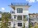 Striking exterior of a modern home with multiple balconies and a rooftop deck, showcasing sleek design at 18077 3Rd St, Redington Shores, FL 33708