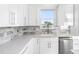Bright kitchen featuring white countertops, stainless steel appliances, and marble backsplash at 18077 3Rd St, Redington Shores, FL 33708