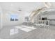 Bright open-concept living space featuring tile flooring and an open staircase at 18077 3Rd St, Redington Shores, FL 33708