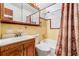 Retro yellow-tiled bathroom features a shower-tub combo, a wood vanity, and a large mirror at 5927 3Rd N Ave, St Petersburg, FL 33710