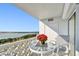 Relaxing balcony with comfortable seating, potted red flowers, and stunning waterfront views at 7 Elgin Pl # 603, Dunedin, FL 34698