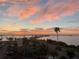 Beautiful sunset reflecting on the bay with the road and buildings with parking in the foreground at 7 Elgin Pl # 603, Dunedin, FL 34698