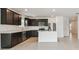 Spacious kitchen featuring dark wood cabinets, stainless steel appliances, and a center island at 12815 Wanderlust Pl, Parrish, FL 34219