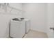 Bright laundry room featuring modern, white appliances and ample shelving for storage at 12815 Wanderlust Pl, Parrish, FL 34219