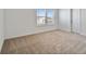 Inviting bedroom with neutral carpet, a window with blinds, and a white door at 12819 Wanderlust Pl, Parrish, FL 34219