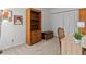 Bedroom area features a wooden bookcase, a vintage trunk, a light wood desk, and neutral carpeting at 1581 Amberlea S Dr, Dunedin, FL 34698