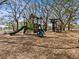 Community playground with slides, climbing structures, and benches amidst mature trees at 1581 Amberlea S Dr, Dunedin, FL 34698