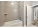 Bathroom featuring a white bathtub with a shower and gray tiling at 2402 Cumberland Cliff Dr, Ruskin, FL 33570