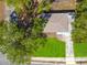 Aerial view of a quaint house surrounded by lush greenery and a well-manicured lawn at 8902 Temple Park Dr, Tampa, FL 33637