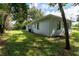Home's backyard features a green lawn and the rear exterior of the house at 8902 Temple Park Dr, Tampa, FL 33637