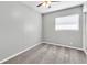 Empty bedroom featuring a neutral carpet, simple fan, a window, and white trim against light grey walls at 8902 Temple Park Dr, Tampa, FL 33637