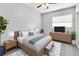 A bright bedroom features a bed, side tables, lamps, a TV on the dresser, ceiling fan, and a patterned rug at 8902 Temple Park Dr, Tampa, FL 33637