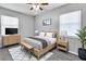 Stylized bedroom with neutral walls and carpets, featuring a bed, side tables, tv, and decor at 8902 Temple Park Dr, Tampa, FL 33637