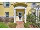 Inviting front entrance of a yellow home, with brick pathway and garden to the main door at 107 Seahorse Se Dr # A, St Petersburg, FL 33705