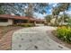 Exterior view of the home with mature landscaping and a spacious driveway at 1545 Park N St, St Petersburg, FL 33710
