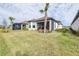 Spacious backyard with a lush lawn, featuring screened patios for outdoor living at 4639 Garofalo Rd, Wesley Chapel, FL 33543