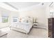 Bright bedroom features a plush bed, soft carpet, and windows offering serene views of the outdoors at 4639 Garofalo Rd, Wesley Chapel, FL 33543