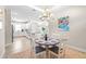 Dining area featuring a chandelier, seating for four, with an adjacent kitchen at 4639 Garofalo Rd, Wesley Chapel, FL 33543